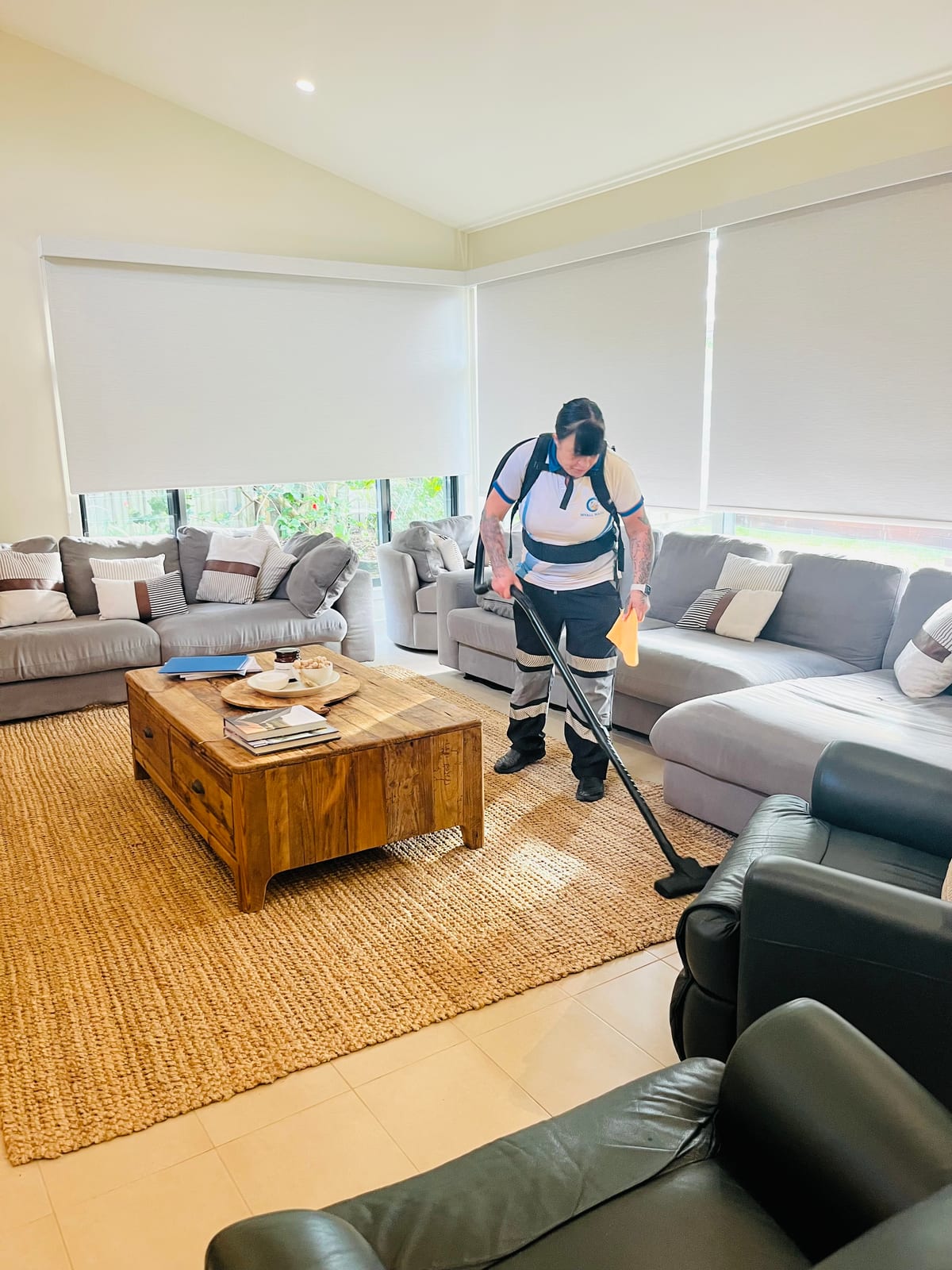 A Myall Maids team member vacuuming a family lounge room